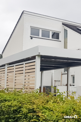 Weißer Carport mit Wandelementen aus naturbelassener Weißtanne