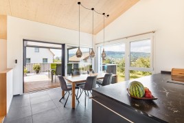 Klimaholzhaus made of LIGNO® mit Seesicht vom Oberdeck und mit der Landschaft geplant