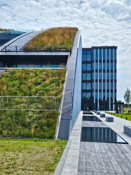 Von Ost nach West in Grün gehüllt. Der Innovationsbogen in Augsburg mit einem Schrägdach vom Marktführer.